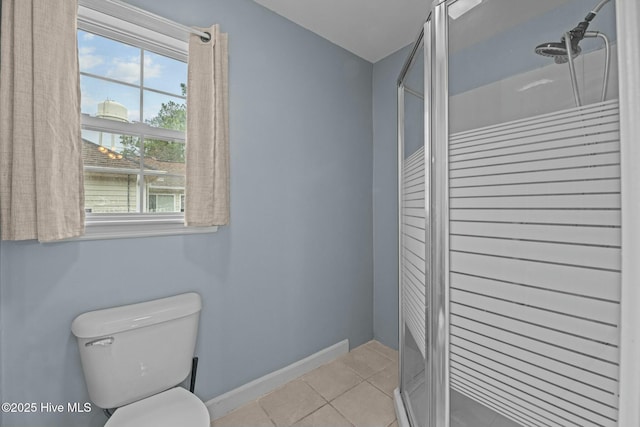 bathroom featuring tile patterned flooring, toilet, and walk in shower