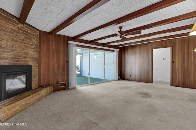 living room featuring ceiling fan, carpet, beam ceiling, and a fireplace