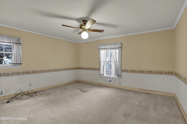 empty room featuring light carpet, ceiling fan, and crown molding