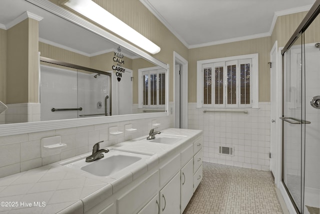 bathroom featuring tile walls, a shower with door, and ornamental molding