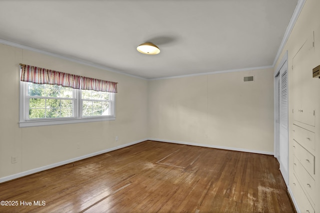 unfurnished room featuring crown molding and hardwood / wood-style floors