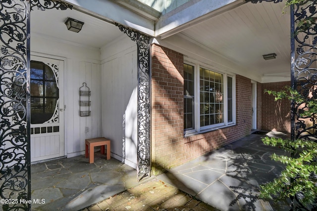 view of exterior entry featuring covered porch