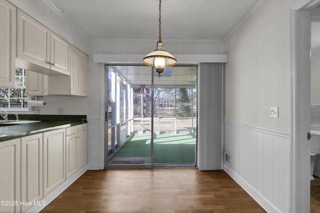 doorway featuring crown molding, dark hardwood / wood-style flooring, and a healthy amount of sunlight