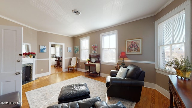 interior space featuring crown molding, wood finished floors, visible vents, and a premium fireplace