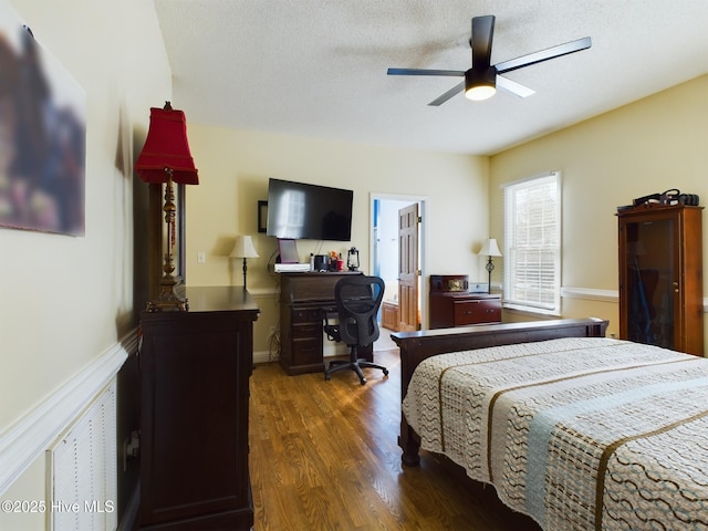 bedroom featuring a textured ceiling, ceiling fan, and dark hardwood / wood-style flooring