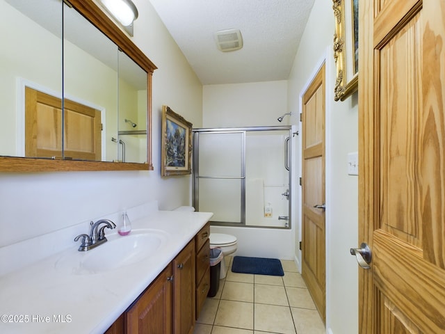 full bathroom with a textured ceiling, enclosed tub / shower combo, tile patterned flooring, vanity, and toilet