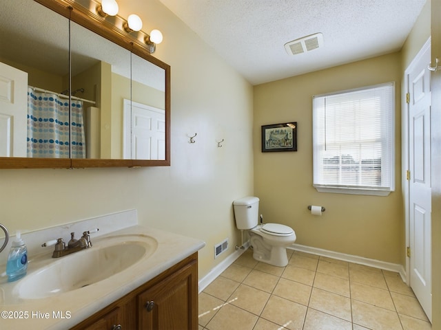 bathroom featuring toilet, tile patterned flooring, walk in shower, a textured ceiling, and vanity