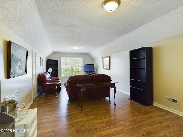 interior space featuring a textured ceiling, dark hardwood / wood-style floors, and vaulted ceiling