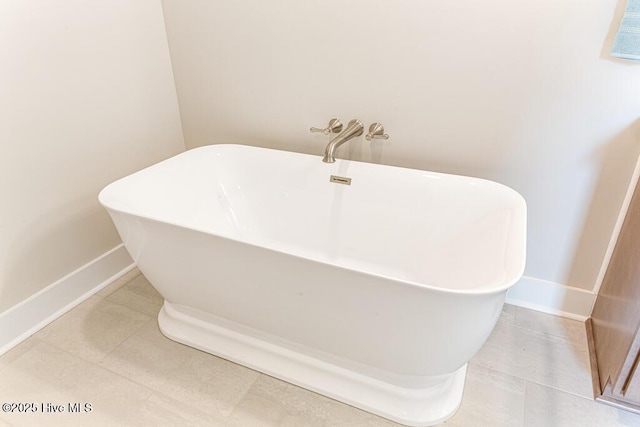 bathroom with a tub to relax in and tile patterned flooring