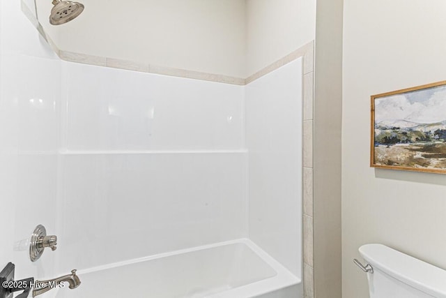 bathroom featuring shower / tub combination and toilet