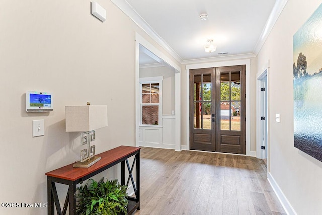 entryway featuring light hardwood / wood-style floors, ornamental molding, and french doors