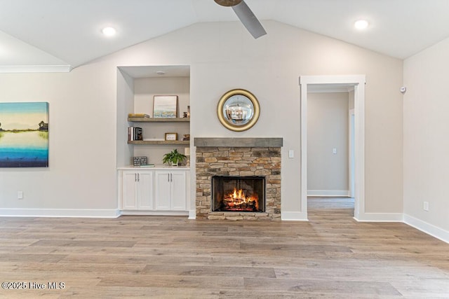 unfurnished living room with vaulted ceiling, ceiling fan, a fireplace, and light hardwood / wood-style floors