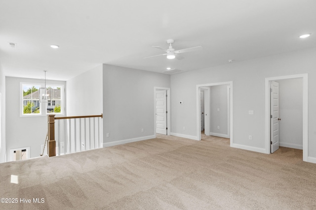 unfurnished room featuring light colored carpet and ceiling fan with notable chandelier