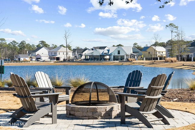 exterior space featuring a water view and an outdoor fire pit