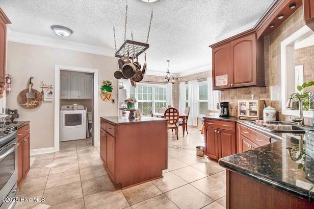 kitchen featuring ornamental molding, sink, washer / dryer, and a center island