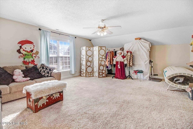 sitting room featuring ceiling fan, a textured ceiling, carpet, and vaulted ceiling