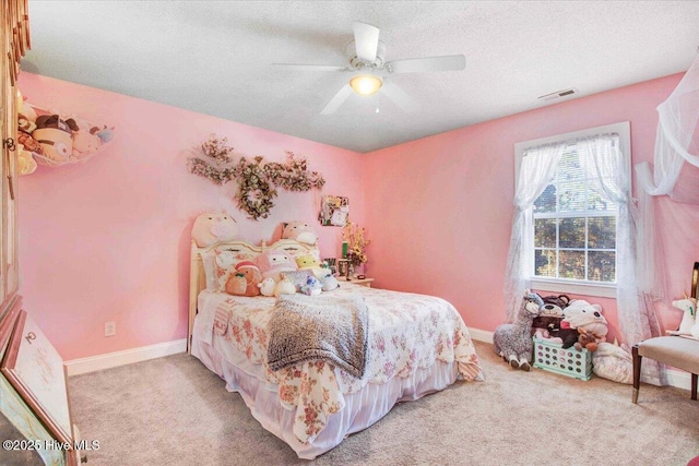 carpeted bedroom featuring ceiling fan and a textured ceiling