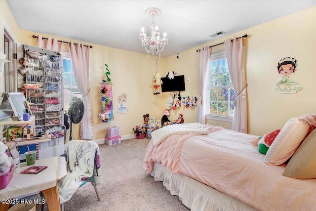 bedroom featuring carpet, a textured ceiling, and an inviting chandelier