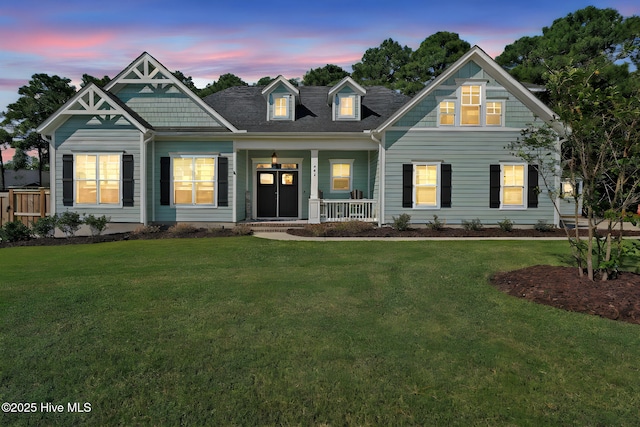 view of front of home featuring covered porch and a lawn