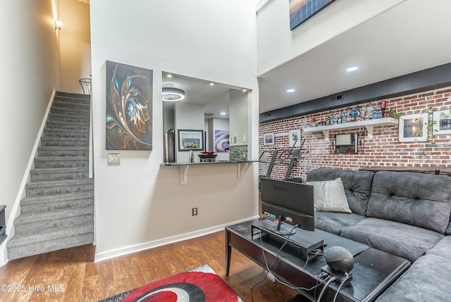 living room featuring brick wall and hardwood / wood-style floors