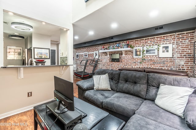 living room with wood-type flooring and brick wall