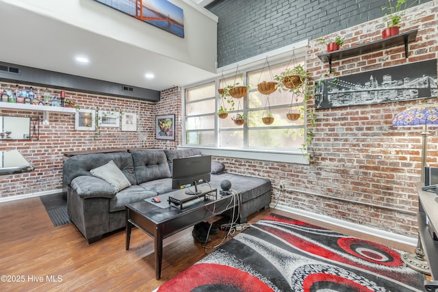 living room featuring light wood-type flooring and brick wall