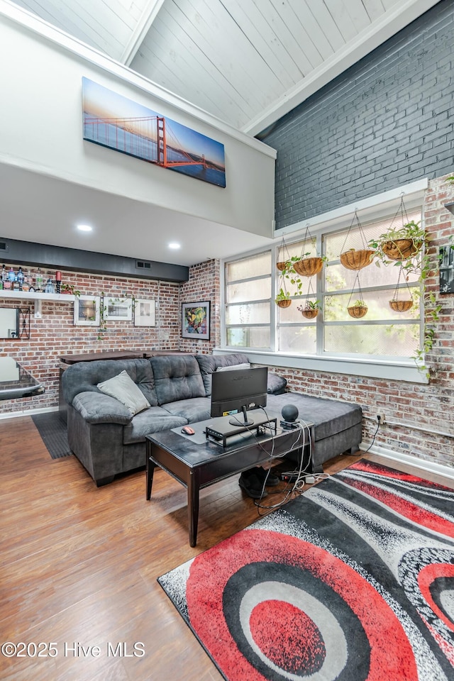 living room with wood ceiling, brick wall, and hardwood / wood-style floors