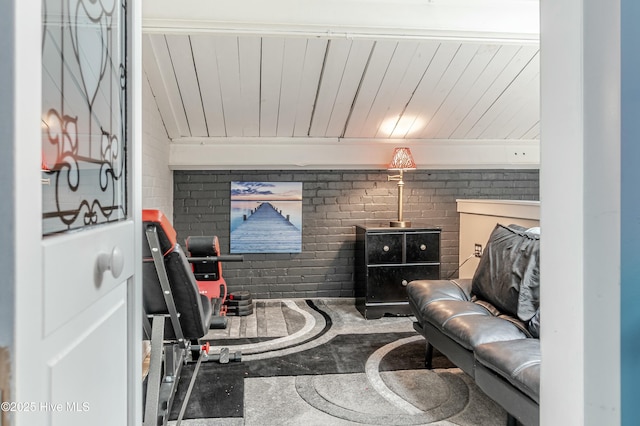 living area featuring brick wall and wood ceiling