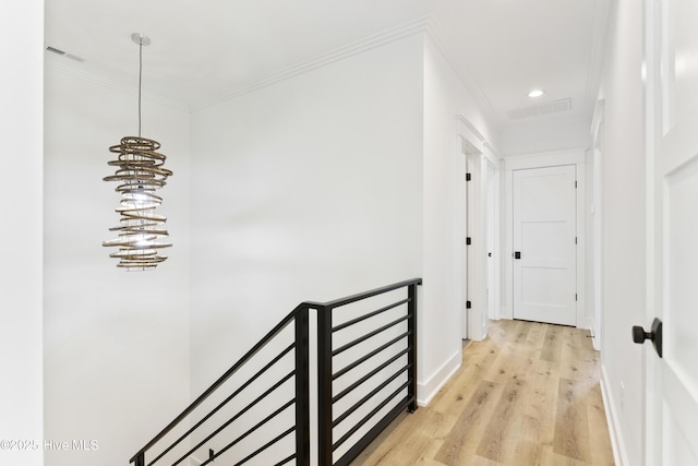 hall featuring crown molding and light hardwood / wood-style flooring