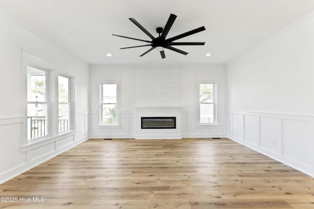 unfurnished living room featuring ceiling fan, crown molding, and light hardwood / wood-style flooring