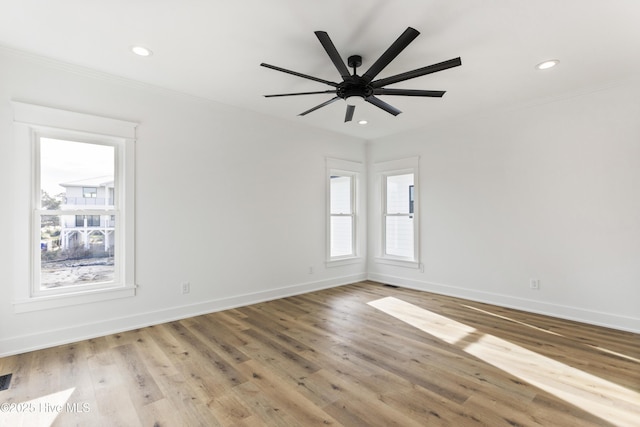 empty room with ceiling fan, light wood-type flooring, and ornamental molding