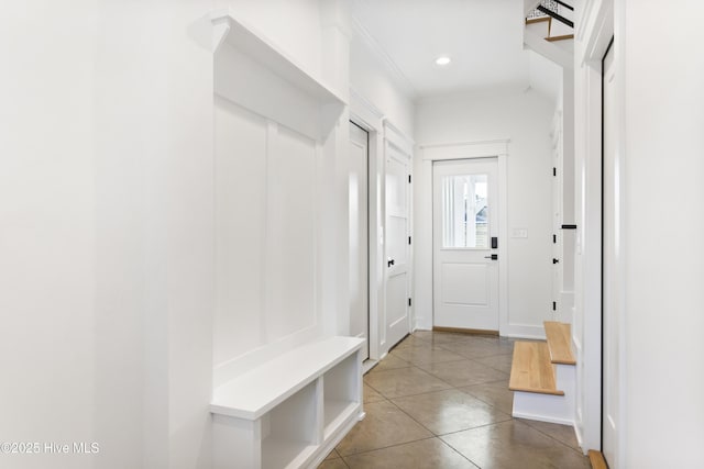 mudroom featuring tile patterned floors and crown molding