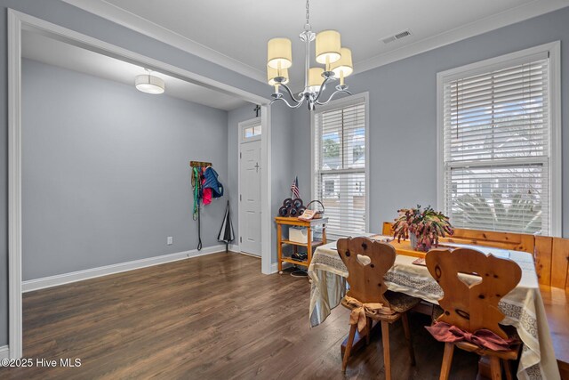 dining room with dark hardwood / wood-style flooring, a notable chandelier, and crown molding