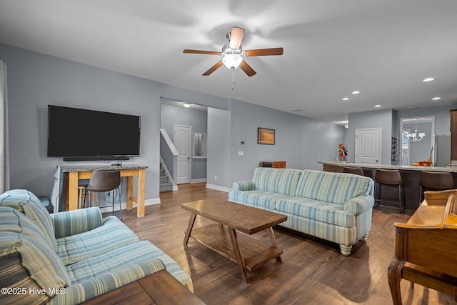 living room featuring hardwood / wood-style flooring and ceiling fan with notable chandelier