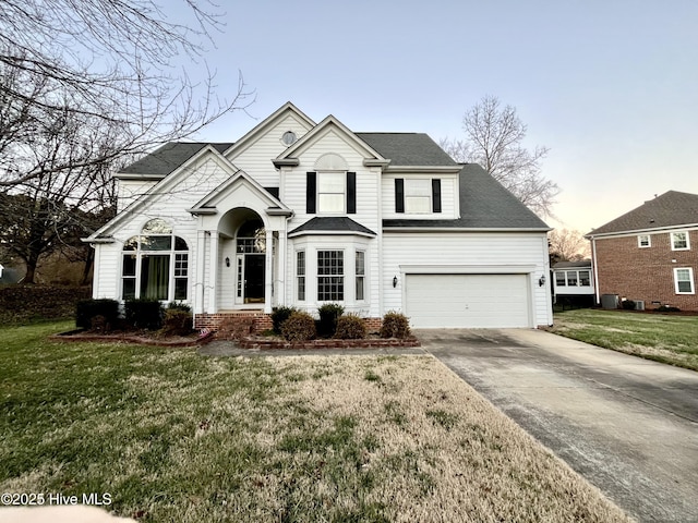 view of front of property with a yard and central AC