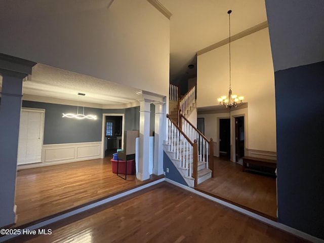 interior space with a chandelier, wood-type flooring, and decorative columns