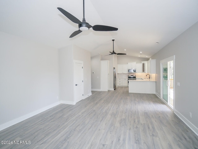 unfurnished living room with ceiling fan, sink, light hardwood / wood-style flooring, and lofted ceiling