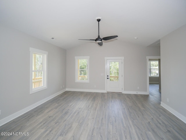 spare room with light wood-type flooring, vaulted ceiling, and ceiling fan