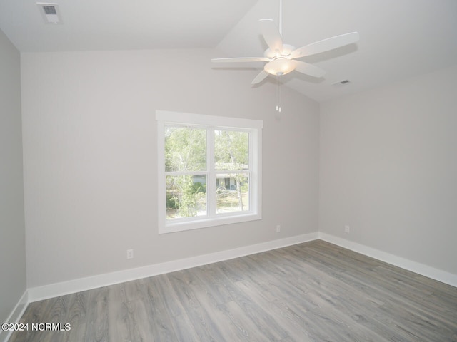 spare room with vaulted ceiling, ceiling fan, and light hardwood / wood-style flooring