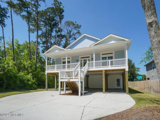 raised beach house with covered porch and a carport