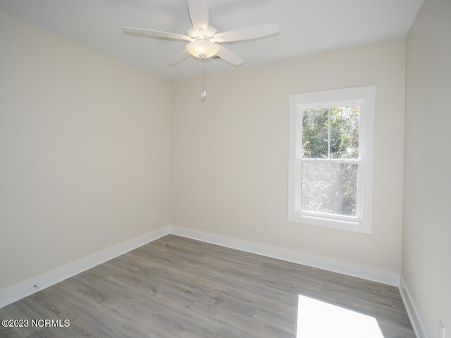 spare room with ceiling fan, baseboards, and wood finished floors