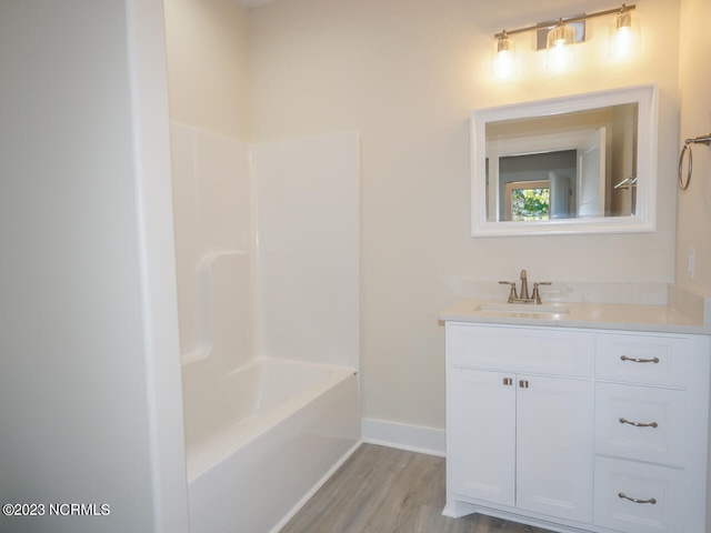 bathroom with hardwood / wood-style floors, vanity, and shower / bathing tub combination