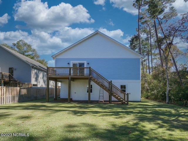 rear view of house with a deck, stairs, a yard, and fence