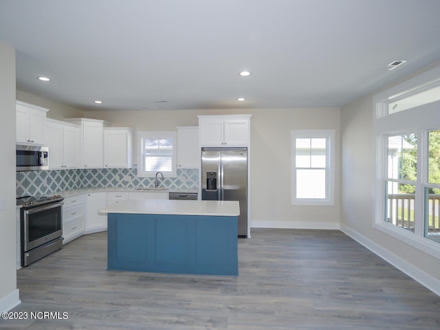 kitchen featuring a sink, a center island, backsplash, and stainless steel appliances