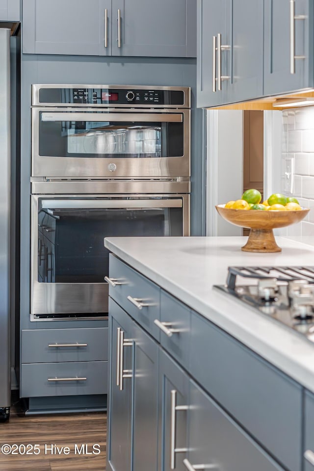 kitchen featuring stainless steel appliances, dark hardwood / wood-style flooring, and tasteful backsplash