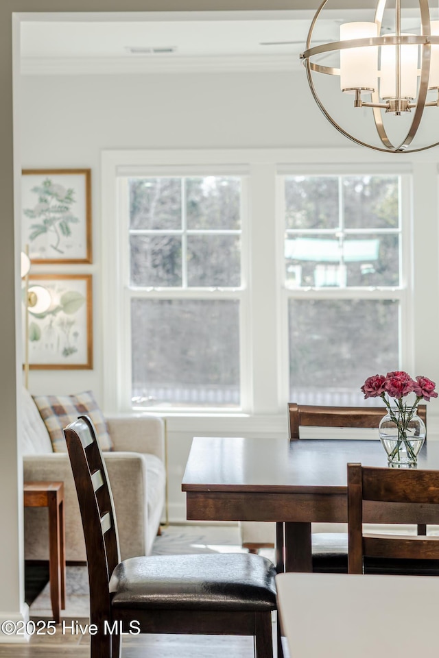 dining space featuring crown molding and an inviting chandelier