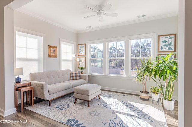 living room with hardwood / wood-style flooring, ornamental molding, and ceiling fan