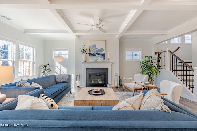 living room with light hardwood / wood-style floors, crown molding, beam ceiling, and coffered ceiling