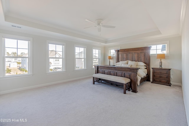 bedroom with ceiling fan, light colored carpet, a tray ceiling, and ornamental molding