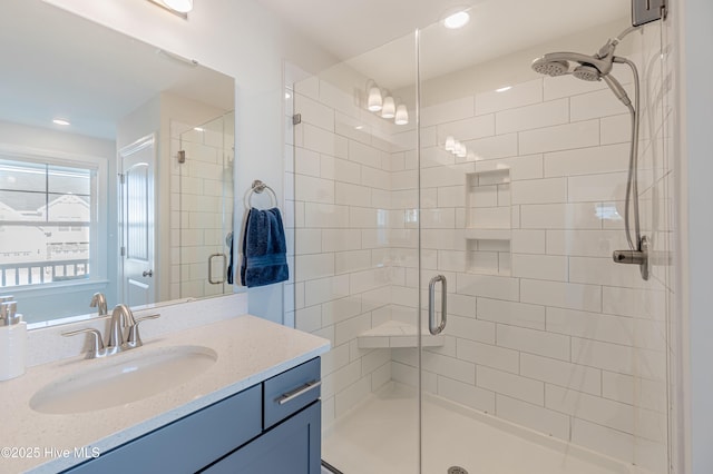 bathroom with vanity and a shower with door